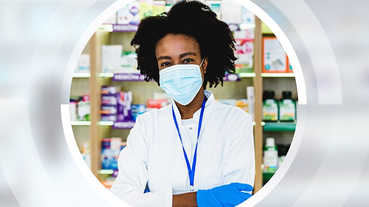A pharmacist wears a face mask and gloves to help protect herself against COVID-19.