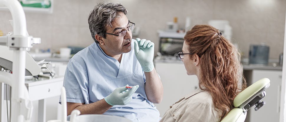 Image of dentist giving oral health education to patient