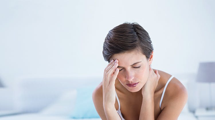 Woman touching her forehead in pain