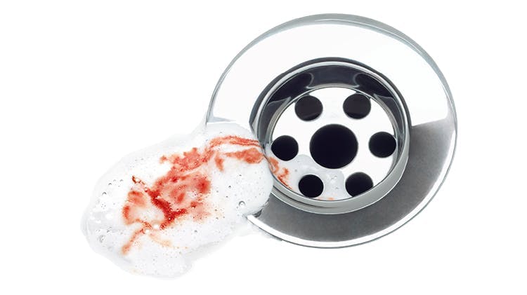 Image of toothpaste with blood in it going down a drain