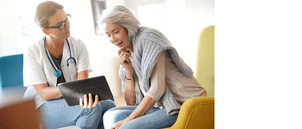 A young female physician conversing with an elderly woman