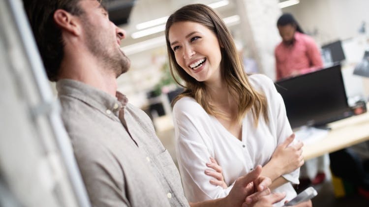 A man and a woman laugh together, showing their clean, white and healthy teeth.