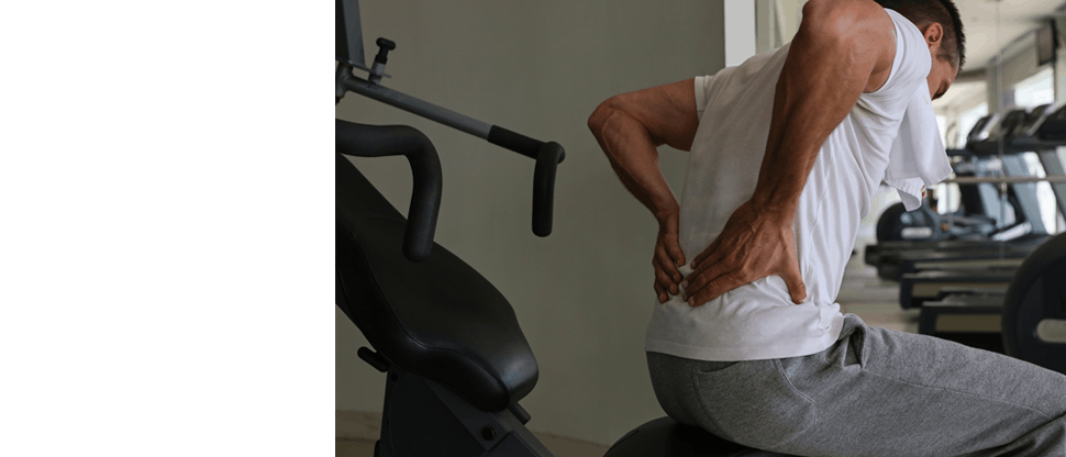 Man holdering his lower back with both hands 