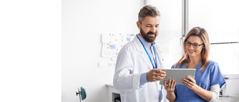 A male doctor and a female nurse reading something on a tablet