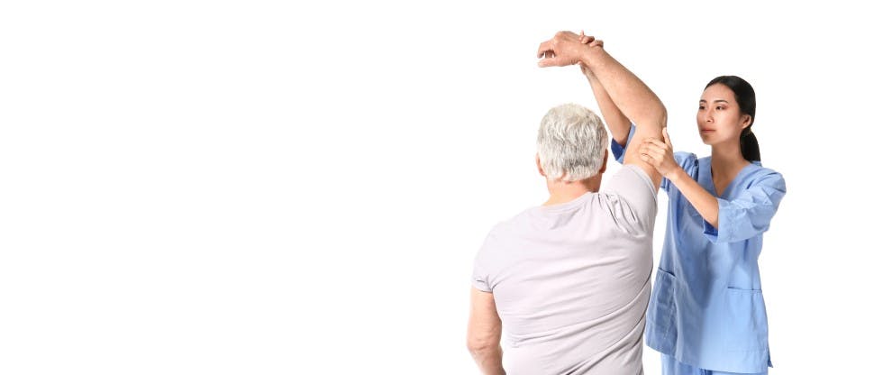 Physiotherapist doing check-up of the elbow of an older man 