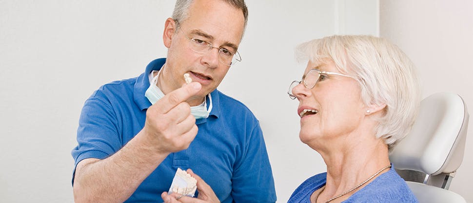 Man showing woman a denture