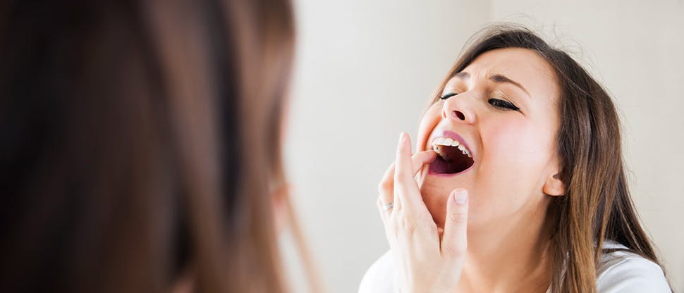 Woman looking at her teeth in mirror