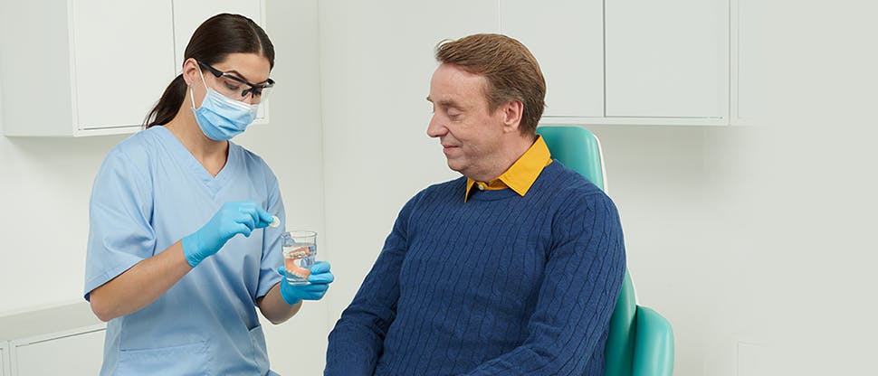 Dentist discussing dentures with smiling patient