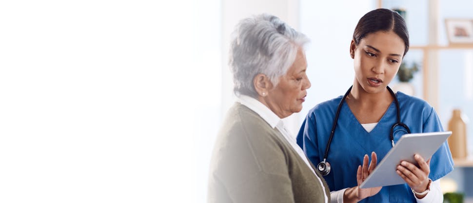 A female doctor gives advice to a senior female patient.