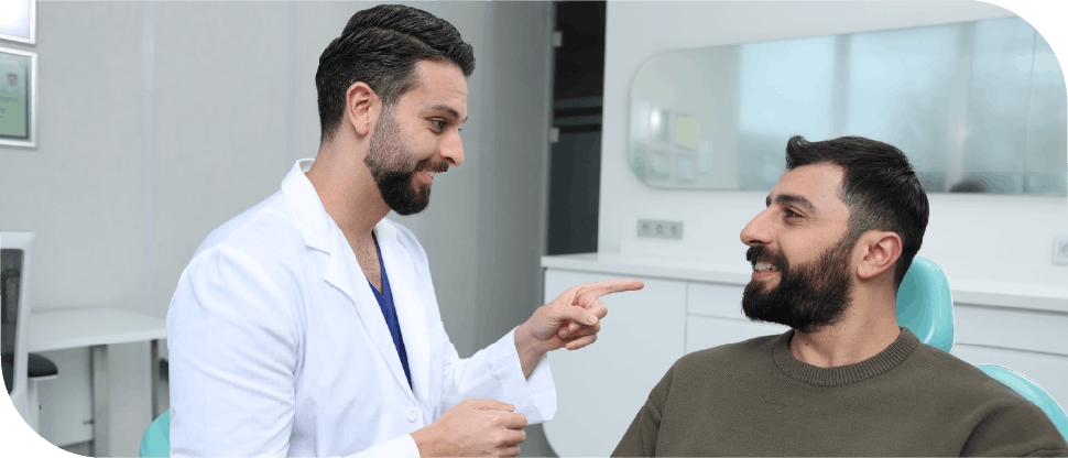 Male Pakistan dentist talking to male patient