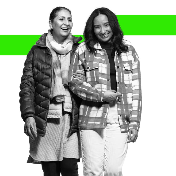 Two women smiling and walking hand in hand