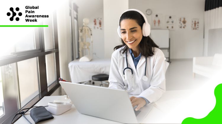 A photo of a young female healthcare professional sitting behind a laptop