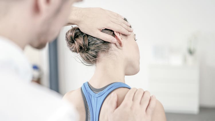 Physiotherapist performing neck stretch on patient