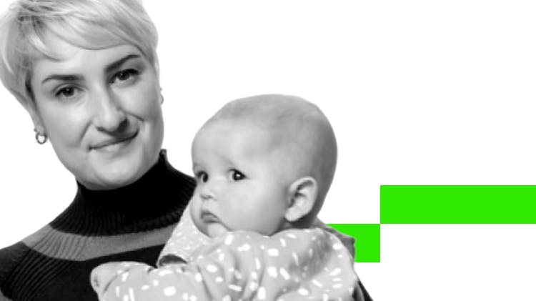 Woman with short blonde hair smiling while holding a small baby