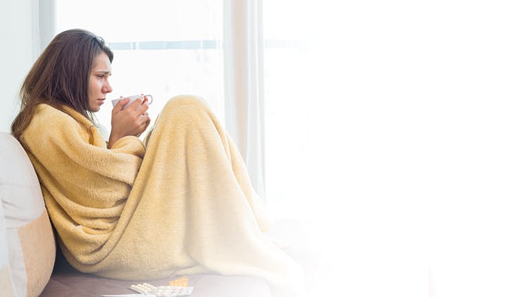 Woman in blanket unwell