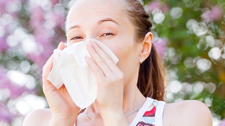 Woman blowing nose