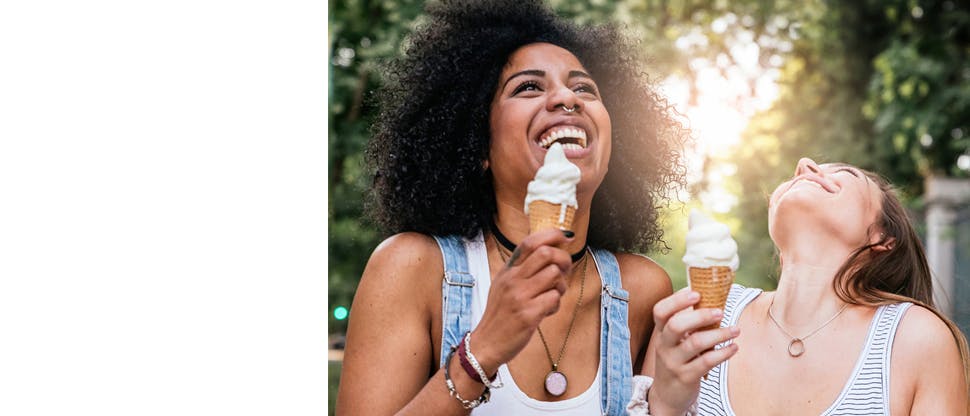 Two girls laughing and holdering icecream 