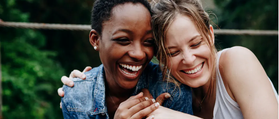 Two women hugging and laughing