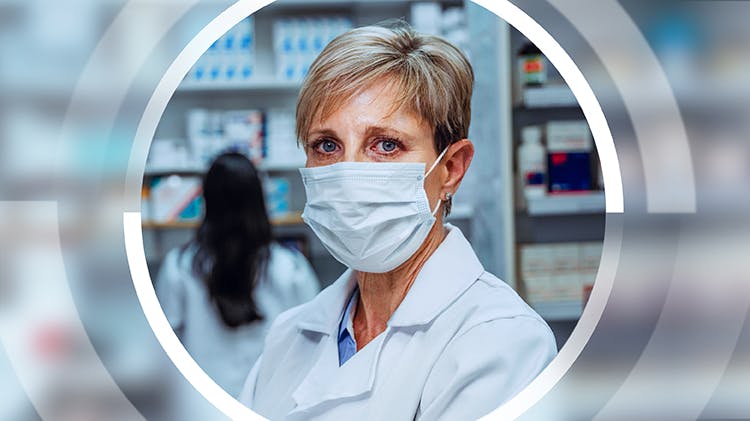 A pharmacist wears a face mask to help protect herself against COVID-19.  