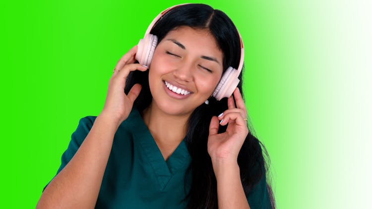 Image of dental hygienist with headphones on, listening to a music playlist