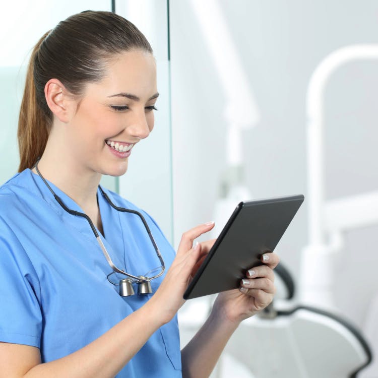 Female dental hygienist using a tablet to join Haleon HealthPartner