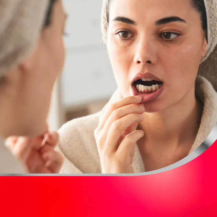 Woman looking at gums in mirror with header Gum Health