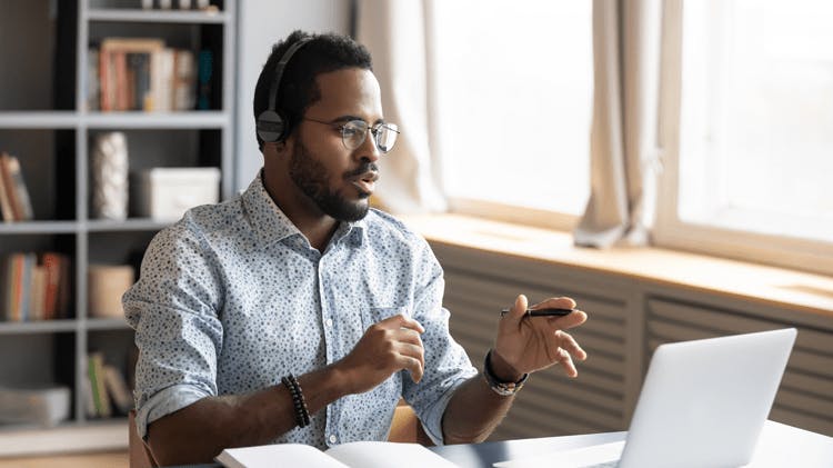 Doctor sitting at desk giving virtual presentation