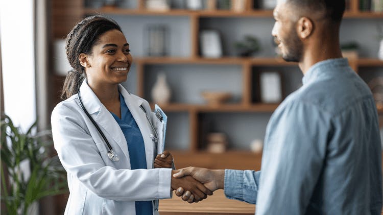 Woman smiling and shaking hands with a doctor