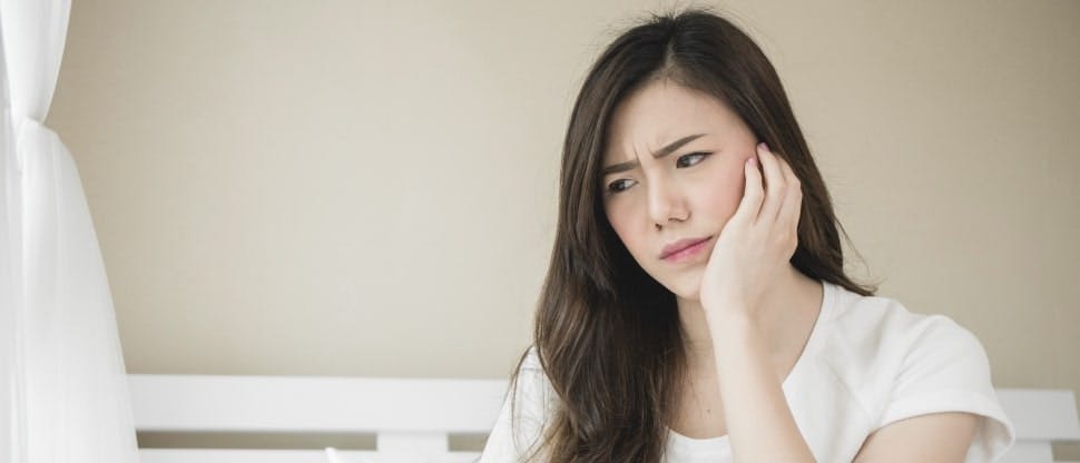 Woman in bed having dental pain