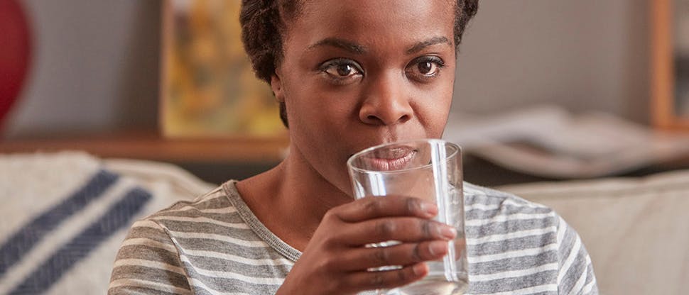 Woman drinking water to treat Dry Mouth