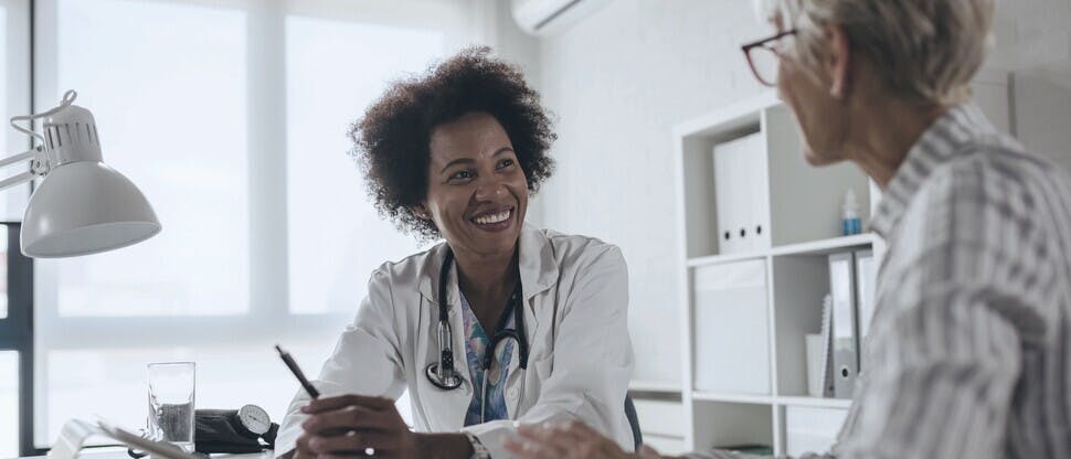 Black female doctor smiling while consulting a patient