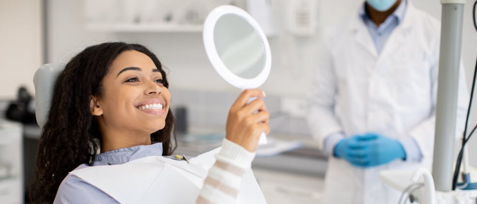 Woman in dentist chair undergoing teeth whitening treatment