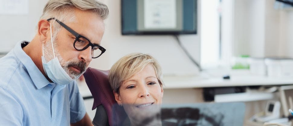 Dentist and patient reviewing dental x-ray