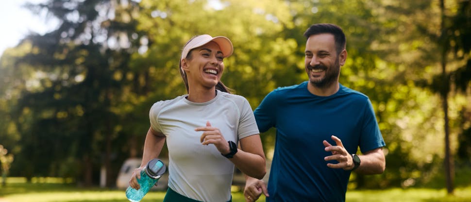 Man and woman running together outside and smiling