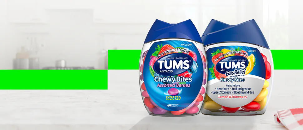 Two Tums Chewy Bites products placed on a countertop. The container on the left is labeled ‘Tums Chewy Bites Assorted Berries,’ and the container on the right is labeled ‘Tums Gas Relief Chewy Bites Lemon & Strawberry
