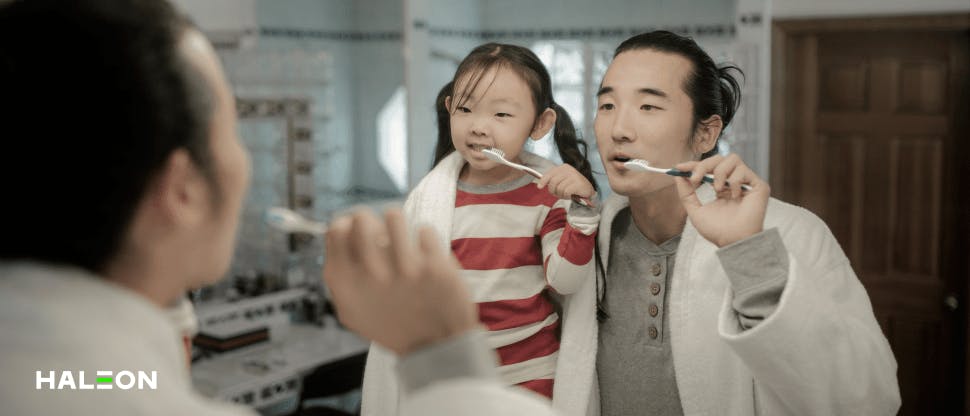 Father and daughter brushing teeth