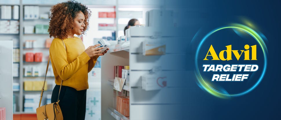 Woman in pharmacy looking at pain relief products