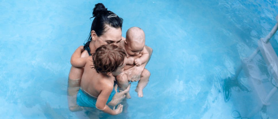 Mom in pool with baby and toddler 