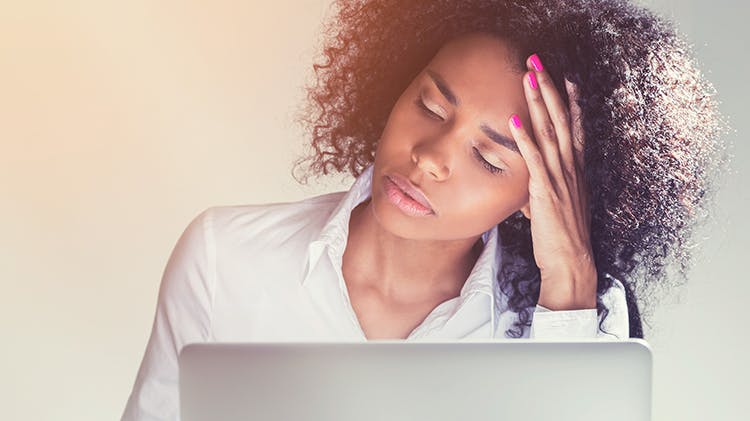 Woman with a migraine massaging her head