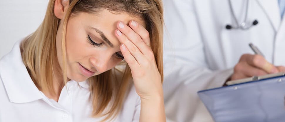 Female patient with headache in doctor’s office