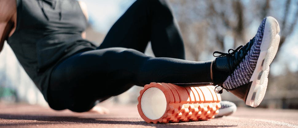 Young man stretching with a foam roller