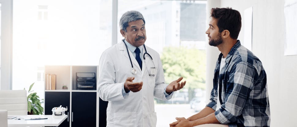 Young man talking to his doctor in the exam room