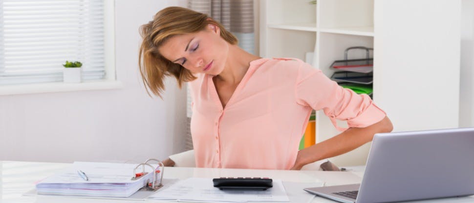 Woman at desk with menstrual pain