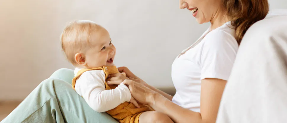 A mother gently holding and comforting her young child in a softly lit room