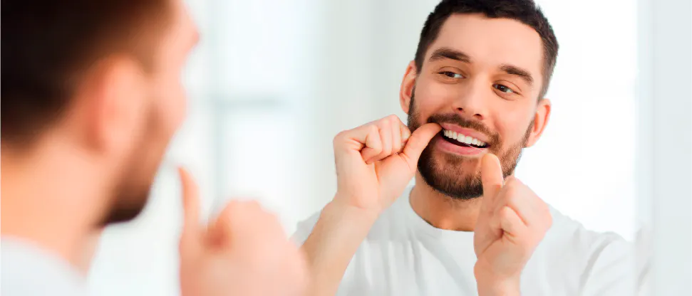 Man flossing in front of mirror