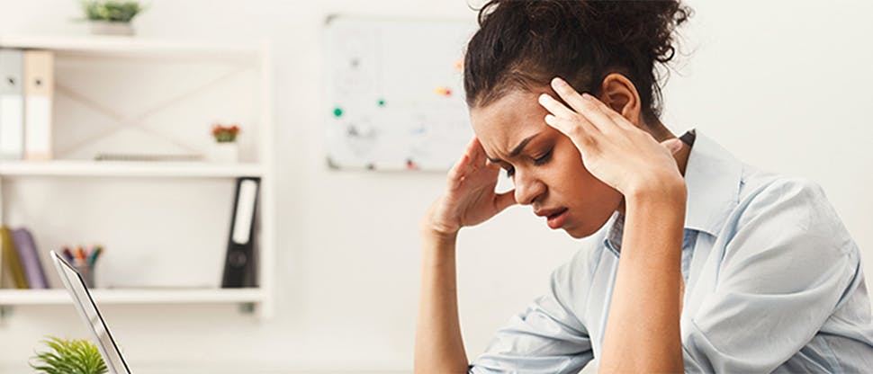 Woman at a desk with a headache