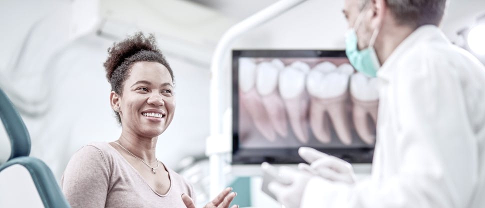 Dentist talking to patient during dental visit