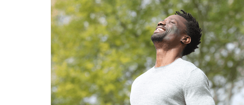 Smiling man facing sunshine
