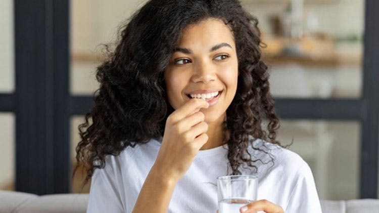 Woman taking a Calpol paracetamol product for pain relief