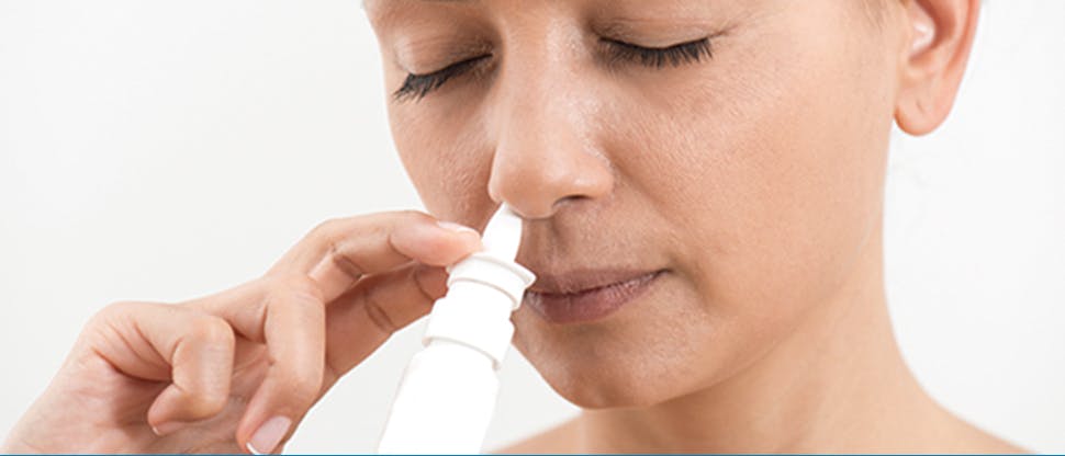 Woman using nasal spray